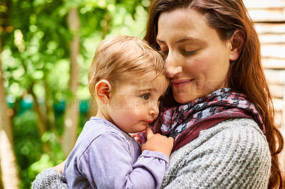 Buy stock photo Shot of a mother holding her baby girl in her arms outside