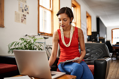Buy stock photo Shot of a young professional working on a laptop in an office