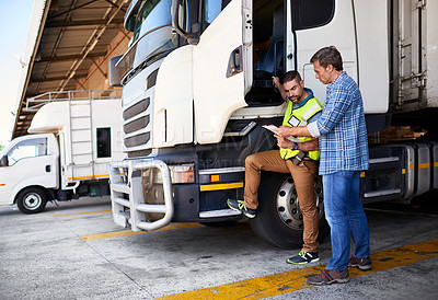 Buy stock photo Shot of two coworkers talking together next to a large truck outside of a distribution center