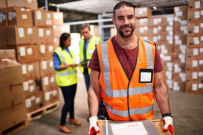 Buy stock photo Portrait of a worker standing in a large warehouse full of boxes with colleagues in the background