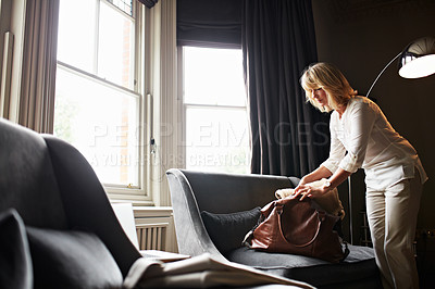 Buy stock photo Shot of a attractive mature woman packing for a business trip