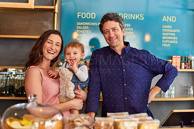 Buy stock photo Portrait of a smiling couple and their little girl standing in their bakery