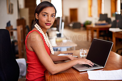 Buy stock photo Portrait of a young woman working on a laptop in an office
