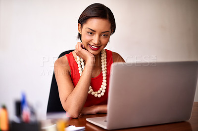 Buy stock photo Shot of a young woman working on a laptop in an office