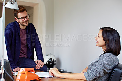 Buy stock photo Shot of a pregnant woman and her husband talking together in their home office