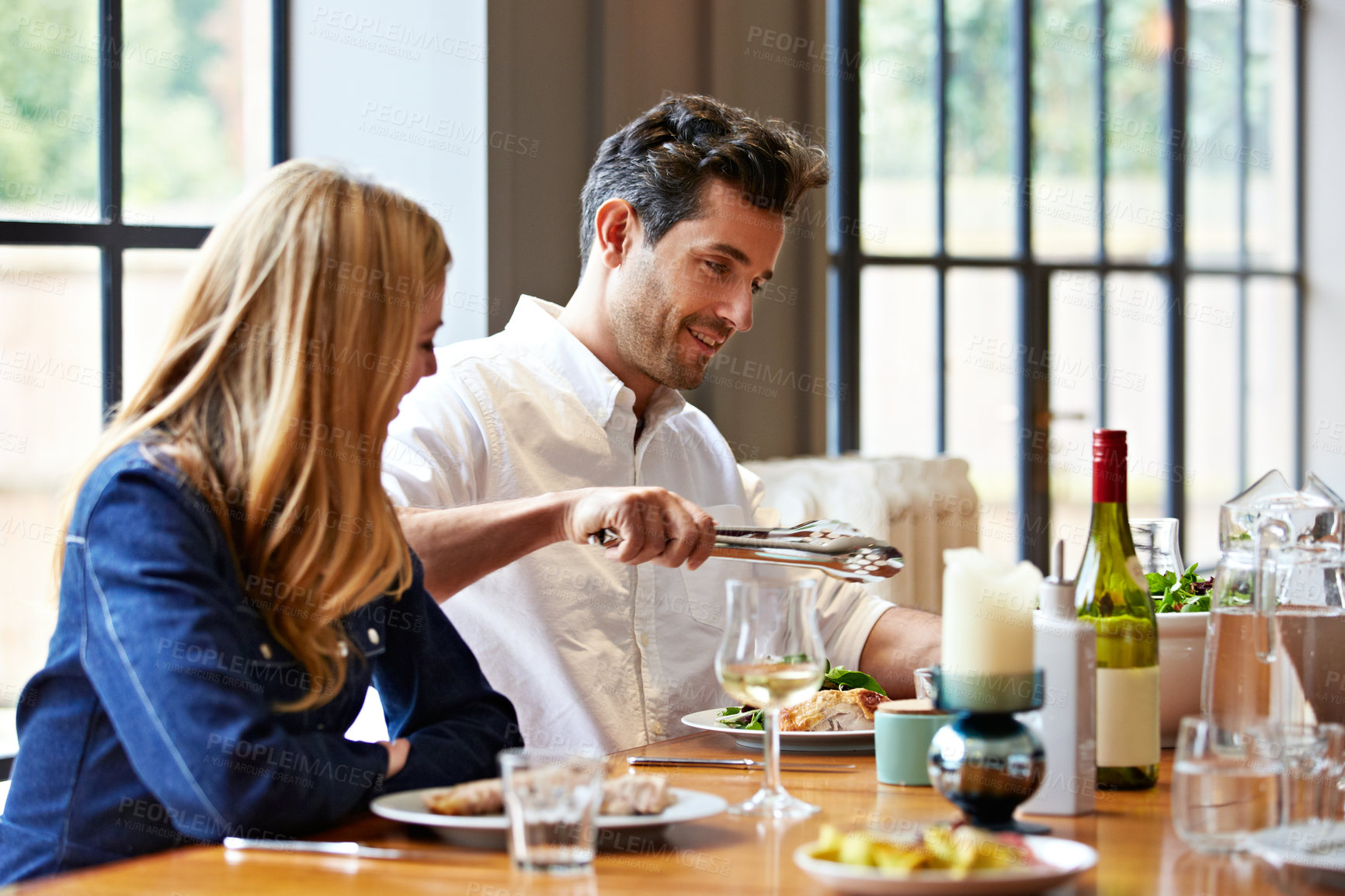 Buy stock photo Shot of a young couple having dinner together