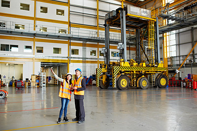 Buy stock photo Shot of two dock workers standing in a dockyard