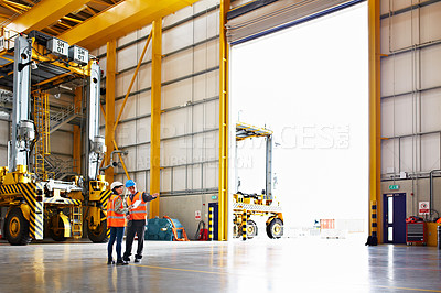 Buy stock photo Shot of two dock workers standing in a dockyard