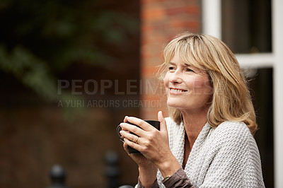 Buy stock photo Shot of a mature woman drinking a cup of coffee on her porch
