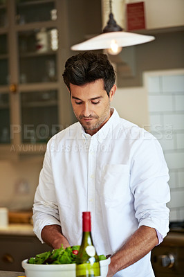 Buy stock photo Shot of a young man preparing dinner in the kitchen