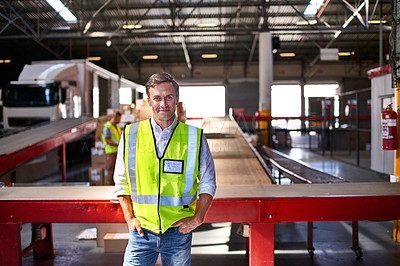 Buy stock photo Portrait of a smiling worker standing in a large warehouse full of boxes