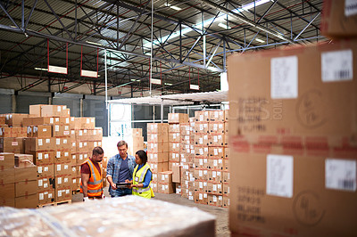 Buy stock photo Shot of people at work in a large warehouse full of boxes