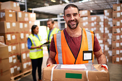 Buy stock photo Portrait of a worker holding a package while standing in a large warehouse full of boxes with colleagues in the background