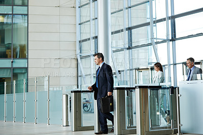 Buy stock photo Shot of businesspeople walking through the lobby of an office building