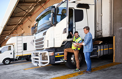 Buy stock photo Shot of two coworkers talking together next to a large truck outside of a distribution center