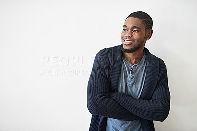 Buy stock photo Studio shot of a smiling young man standing with his arms crossed against a gray background