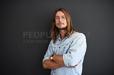 Buy stock photo Studio portrait of a smiling young man standing with his arms crossed against a gray background