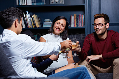 Buy stock photo Shot of a group of friends making a toast while enjoying a night in together at home