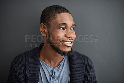 Buy stock photo Studio shot of a smiling young man standing against a gray background