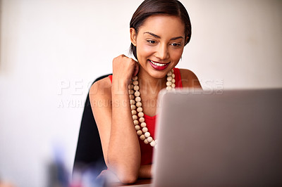 Buy stock photo Shot of a young woman working on a laptop in an office