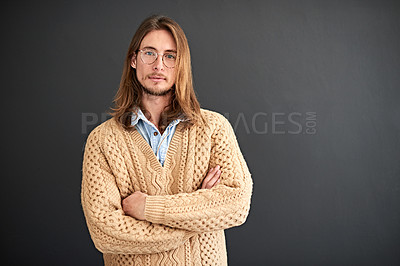 Buy stock photo Studio portrait of a smiling young man standing with his arms crossed against a gray background