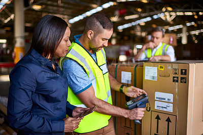 Buy stock photo Shot of workers scanning boxes with a barcode reader while working inside a large warehouse