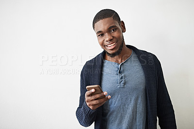 Buy stock photo Studio portrait of a young man using a cellphone against a gray background