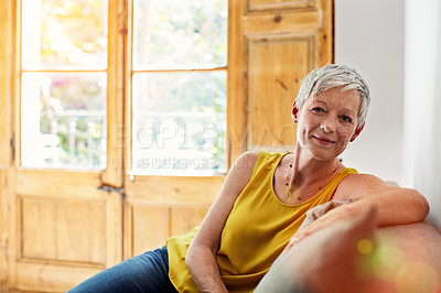 Buy stock photo Portrait of a smiling mature woman relaxing on her sofa at home