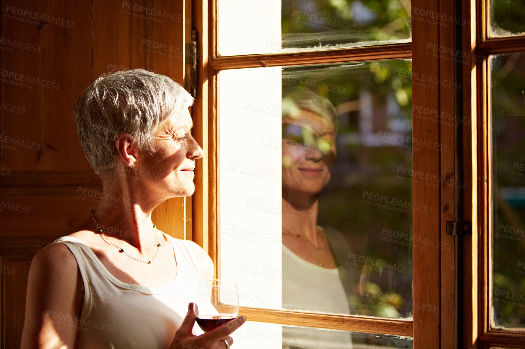 Buy stock photo Senior, woman and wine by window with thinking, sunshine and perspective on future with relax in home. Person, smile and reflection with view, drink and mindfulness with rest mindset and beverage