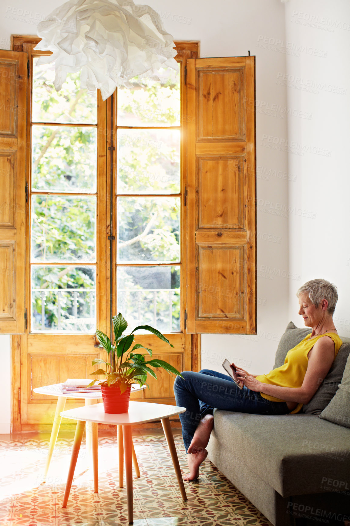 Buy stock photo Mature, woman and happy on couch with tablet, connectivity and scroll for online news, reading and relax. Person, digital tech or ebook on app with internet, newsletter or blog with network at house