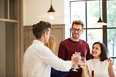 Buy stock photo Shot of two couples talking and toasting together while enjoying a get-together at home