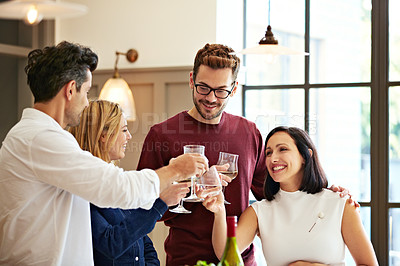 Buy stock photo Shot of two couples talking and toasting together while enjoying a get-together at home