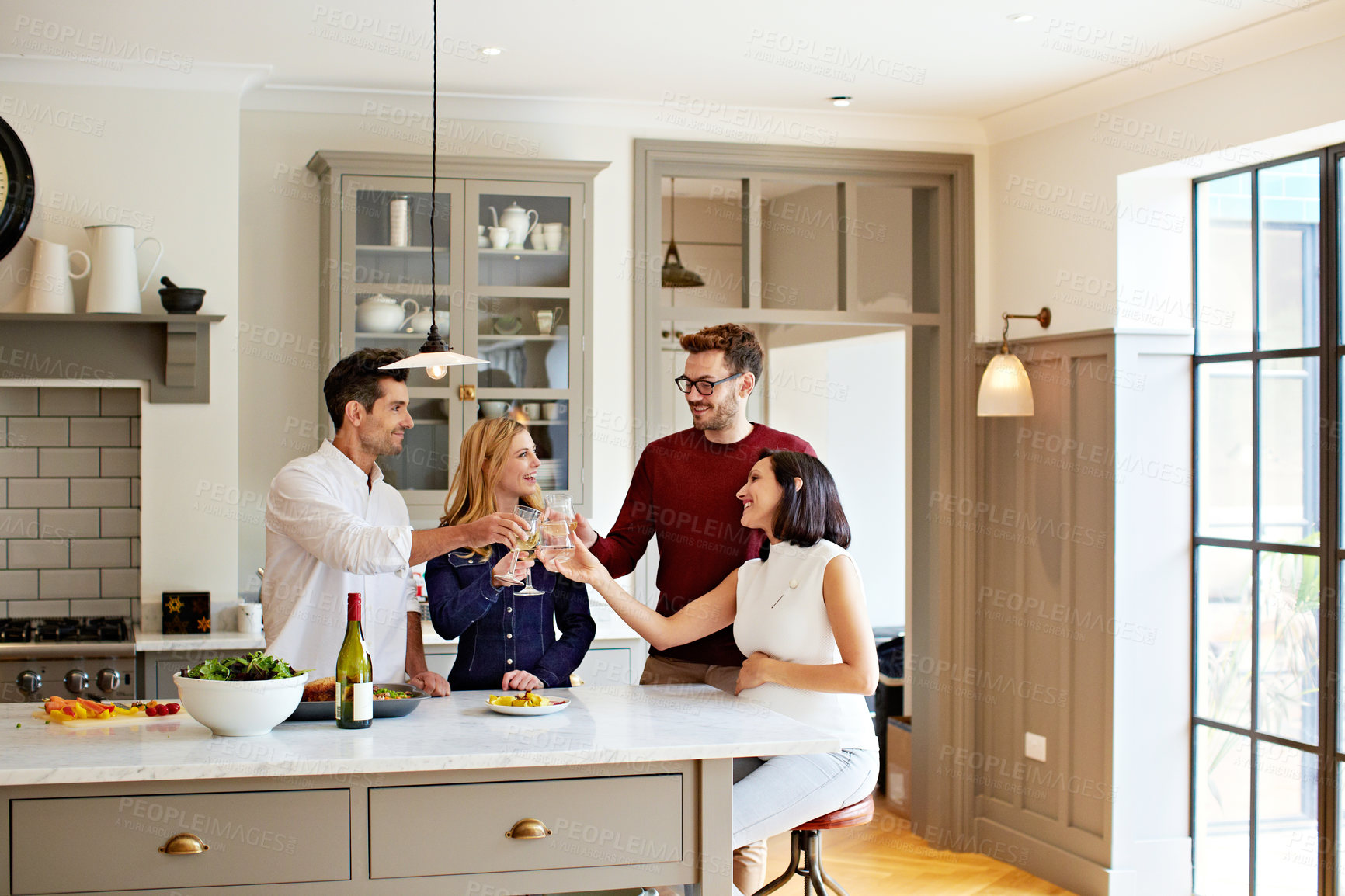 Buy stock photo Shot of two couples talking and toasting together while enjoying a get-together at home