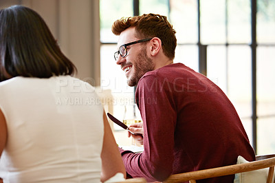 Buy stock photo Shot of a young man enjoying the conversation over dinner