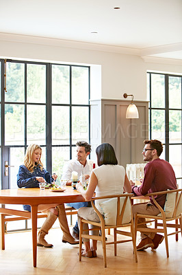 Buy stock photo Shot of a group of friends enjoying a home-cooked dinner together