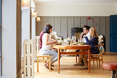 Buy stock photo Shot of a group of friends enjoying a home-cooked dinner together