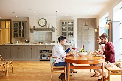 Buy stock photo Shot of a group of friends enjoying a home-cooked dinner together
