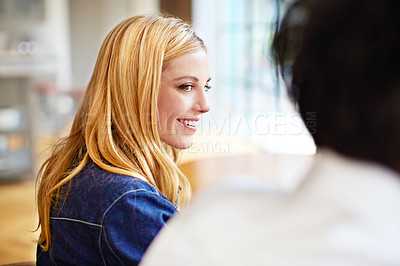Buy stock photo Shot of a young woman enjoying the conversation over dinner