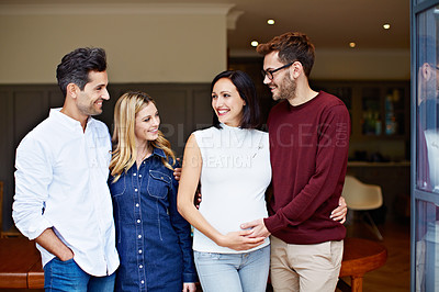 Buy stock photo Shot of a group of friends talking together in a kitchen at a get-together