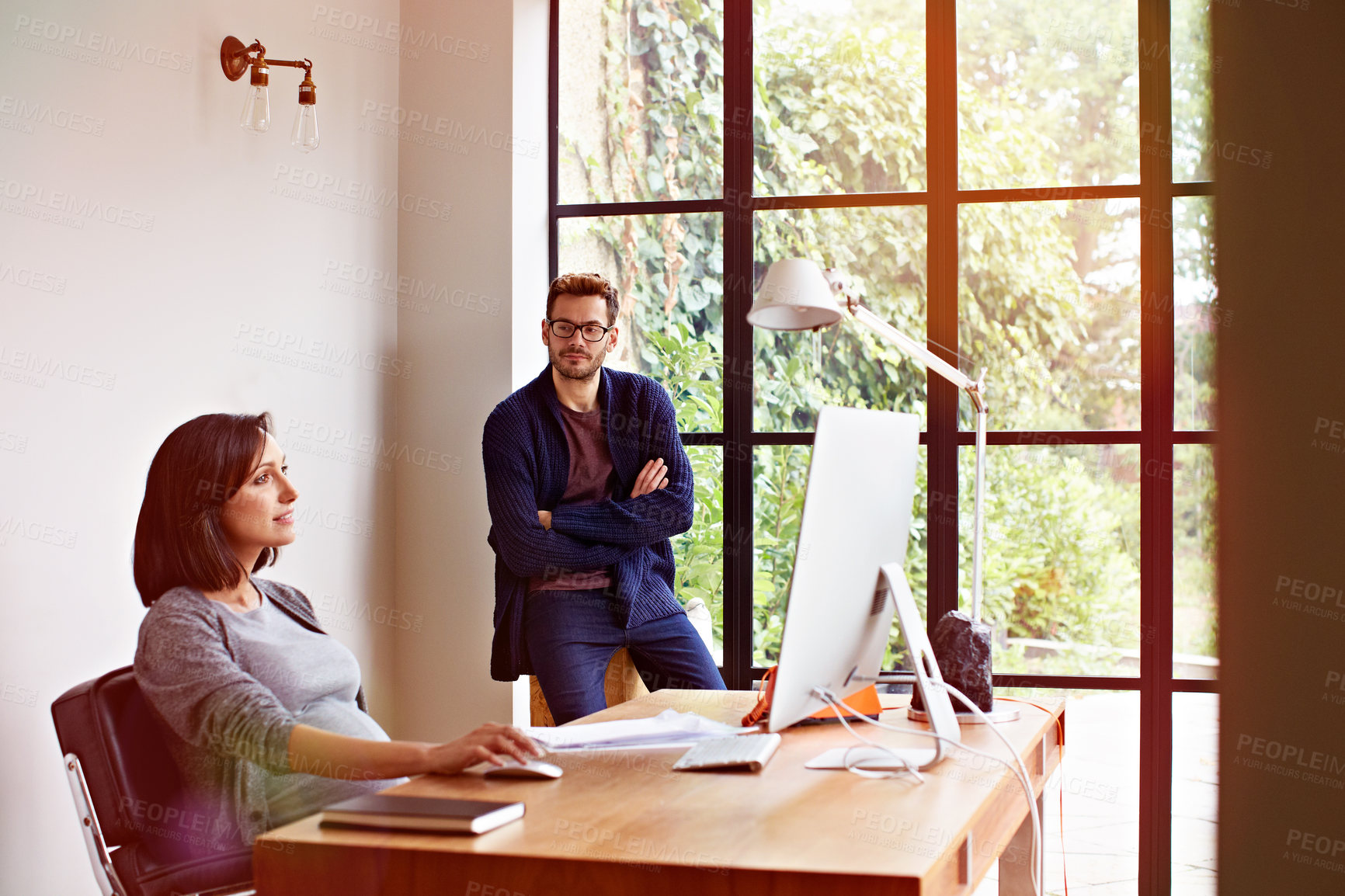 Buy stock photo Shot of an expecting couple working together in their home office