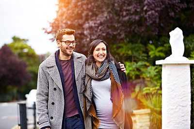 Buy stock photo Shot of a young pregnant woman and her husband enjoying a walk together