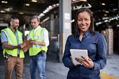 Buy stock photo Portrait of a warehouse manager holding a digital tablet with workers in the background