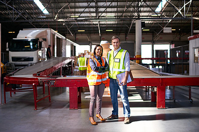 Buy stock photo Portrait of two coworkers talking together inside a large warehouse