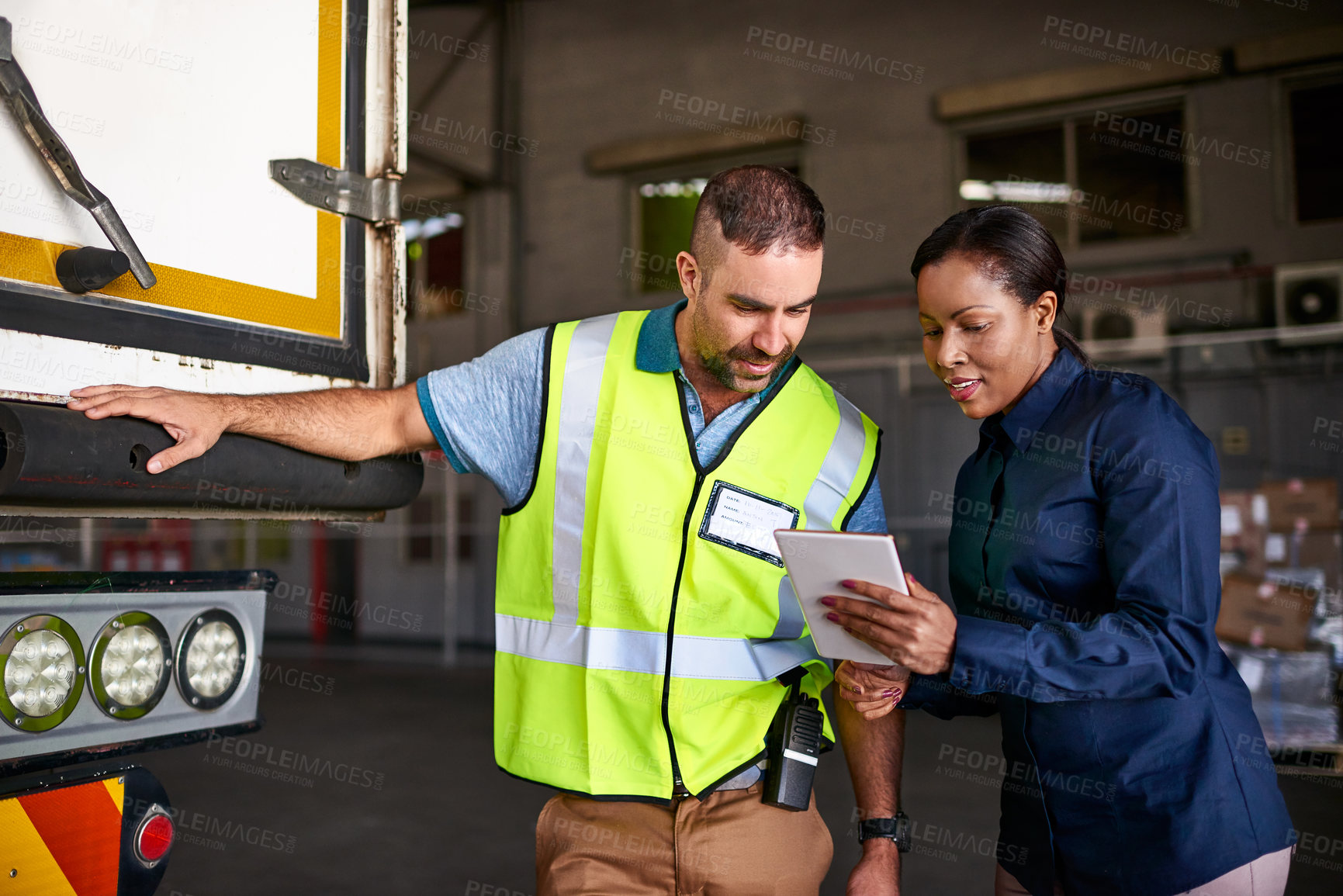 Buy stock photo Shot of a manager holding a digital tablet and talking to a truck driver on the loading dock of a large warehouse