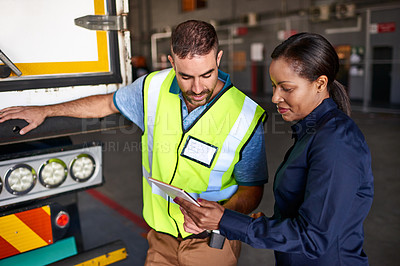 Buy stock photo Shot of a manager holding a digital tablet and talking to a truck driver on the loading dock of a large warehouse