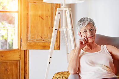 Buy stock photo Portrait of a smiling mature woman relaxing on her sofa at home