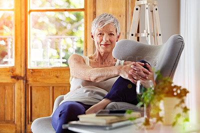 Buy stock photo Portrait of a smiling mature woman relaxing on a chair at home with a glass of wine