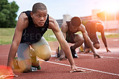 Buy stock photo Shot of a group of runners crouching in starting blocks before a race on a running track