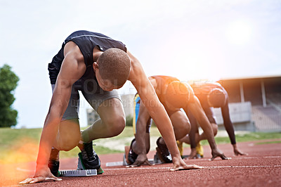 Buy stock photo Shot of a group of runners crouching in starting blocks before a race on a running track
