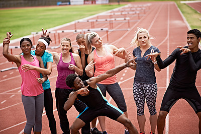 Buy stock photo Portrait of a group of carefree friends in sports clothing standing on a running track